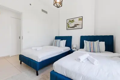two beds sitting next to each other in a room at Town Square Zahra 2B - 2 Bedroom Apartment - Allsopp & Allsopp in Dubai