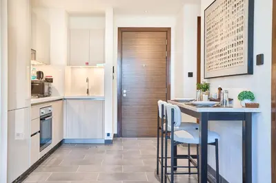 a kitchen with a counter and a table with chairs at STAY BY LATINEM Luxury 1BR Holiday Home CB 0607 Near Burj Khalifa in Dubai