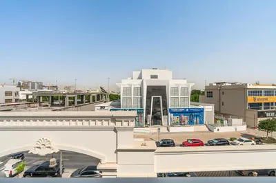 a view of a building with cars parked in a parking lot at Classy Studio APT Close To Dubai Miracle Garden in Dubai