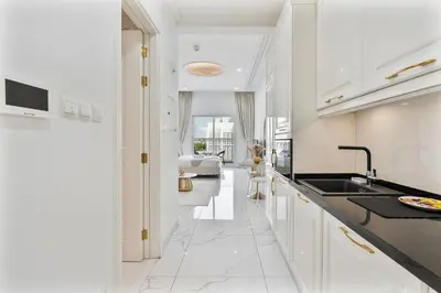 a kitchen with white cabinets and a black counter top at Classy Studio APT Close To Dubai Miracle Garden in Dubai