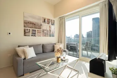 a living room with a couch and a glass table at Dubai Luxury 2BR - Pool, Gym & Burj Khalifa View in Dubai