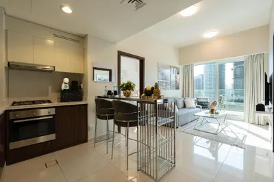 a kitchen and living room with a couch and a table at Dubai Luxury 2BR - Pool, Gym & Burj Khalifa View in Dubai