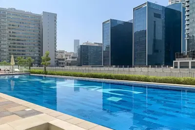 a large blue swimming pool on top of a building at Dubai Luxury 2BR - Pool, Gym & Burj Khalifa View in Dubai