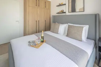 a bedroom with a large white bed with a tray of wine glasses at Frank Porter - Liva, Townsquare in Dubai