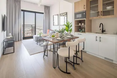 a kitchen and living room with a table and chairs at Frank Porter - Liva, Townsquare in Dubai
