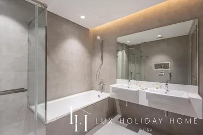 a bathroom with two sinks and a mirror at LUX The Burj Khalifa Lagoon View Suite 4 in Dubai