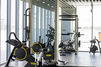 a gym with several treadmills and cardio machines at LUX The Burj Khalifa Lagoon View Suite 4 in Dubai