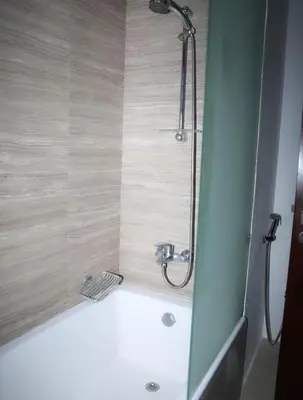 a bathroom with a shower and a bath tub at Elegant Studio with Pool & Gym in JVC in Dubai