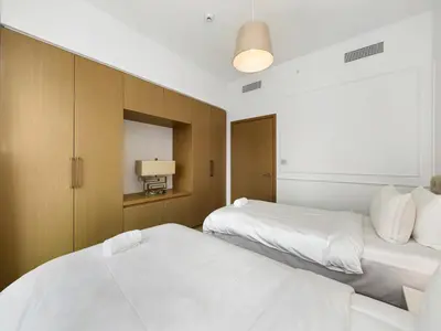two beds in a hotel room with white sheets at ABI Holiday Homes - Burj Khalifa and Fountain view Downtown in Dubai