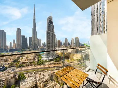 a view of a city skyline with a wooden bench at ABI Holiday Homes - Burj Khalifa and Fountain view Downtown in Dubai