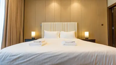a bedroom with a large white bed with towels on it at The Nobles Tower High Floor with Elegant City View in Dubai