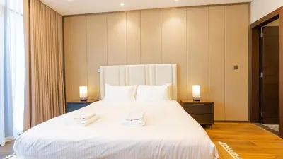 a bedroom with a large white bed with two towels on it at The Nobles Tower High Floor with Elegant City View in Dubai