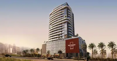 a tall building with palm trees in front of it at Brand New 1BR Apartment in JVC in Dubai