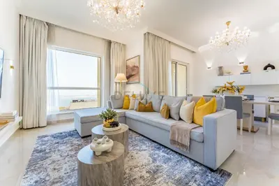 a living room with a blue couch and yellow pillows at Panoramic Sea and Canal Views from High-Floor 2BR, Steps from Tram and Marina Beach, Shams 2, JBR by Dekuxe Holiday Homes in Dubai