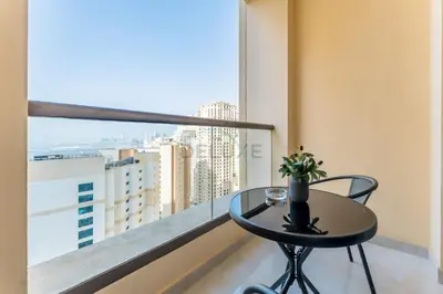 a table on a balcony with a view of a city at Panoramic Sea and Canal Views from High-Floor 2BR, Steps from Tram and Marina Beach, Shams 2, JBR by Dekuxe Holiday Homes in Dubai