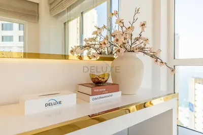 a shelf with a vase and books on it at Panoramic Sea and Canal Views from High-Floor 2BR, Steps from Tram and Marina Beach, Shams 2, JBR by Dekuxe Holiday Homes in Dubai