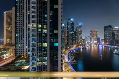a city skyline at night with a river and buildings at GuestReady - Cozy Studio | Pool & Gym | Canal view in Dubai