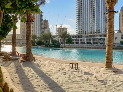 a large swimming pool with palm trees and buildings at Luxury Dubai Creek Beach with Private Lagoon in Dubai