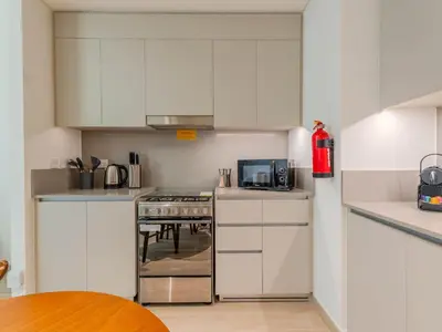a kitchen with white cabinets and a stove top oven at Luxury Dubai Creek Beach with Private Lagoon in Dubai