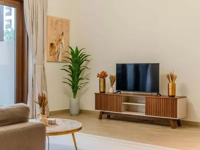 a living room with a flat screen tv on a cabinet at Luxury Dubai Creek Beach with Private Lagoon in Dubai