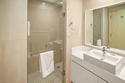 a white bathroom with a sink and a mirror at 1st Row Beach Views with Private Beach and Resort Vibes in Dubai