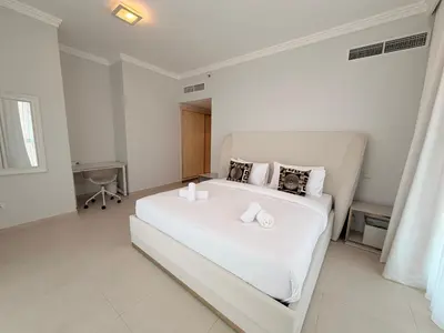 a white bedroom with a large white bed in it at Beachfront Luxury Penthouse at The Walk JBR next to Bluewaters Island - 2BR & Maids Room in Dubai