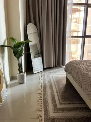 a bedroom with a bed and a mirror and a plant at Amazing 1BR Full Burj View in Dubai
