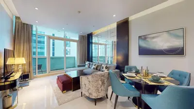 a living room with a couch and a table and chairs at Vacationer l Stylish 1 Bedroom l Downtown Dubai l Pool, Gym Access in Dubai