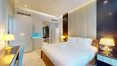 a bedroom with a large white bed and a desk at Vacationer l Stylish 1 Bedroom l Downtown Dubai l Pool, Gym Access in Dubai