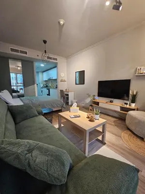 a living room with a couch and a bed and a table at JLT Studio, Steps to Metro, High floor, Smart Home in Dubai