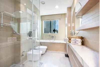 a bathroom with a toilet and a glass shower at Exquisite Marina Home with Panoramic Yacht Views in Dubai