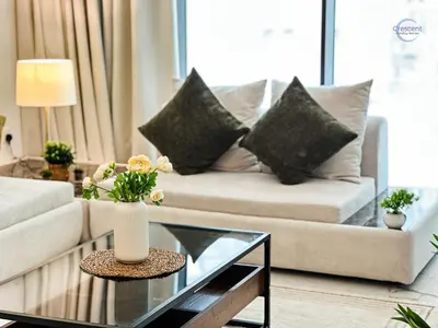 a living room with a couch and a glass table at Modern Retreat at Azizi Azure, Meydan in Dubai