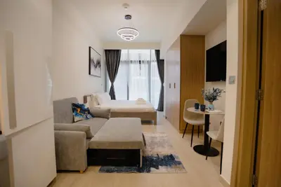 a living room with a couch and a bed at Azizi Modern Studio 10 min to Downtown in Dubai