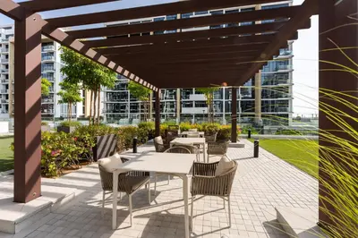 a patio with tables and chairs under a pergola at Bright Designer Stay in Luxurious Comfort in Dubai