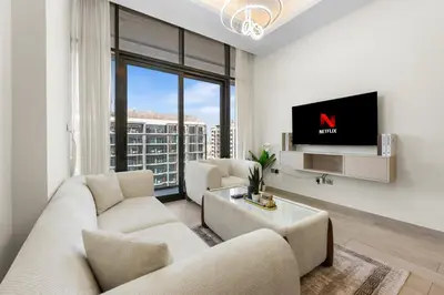 a living room with white furniture and a tv at Bright Designer Stay in Luxurious Comfort in Dubai