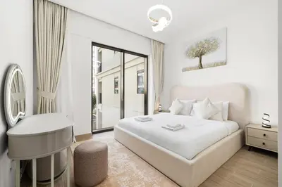 a white bedroom with a white bed and a desk at Creek Beach Sunset 3! Lagoon Access! in Dubai