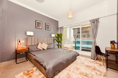 a bedroom with a bed and a desk and a window at Luxury Retreat Your High Floor Heaven in Marina in Dubai