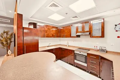 a kitchen with wooden cabinets and a counter top at Luxury Retreat Your High Floor Heaven in Marina in Dubai