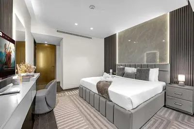 a bedroom with a large white bed and a desk at Lavish Marina Gem - Dubai Eye Views - Infinity Pool in Dubai