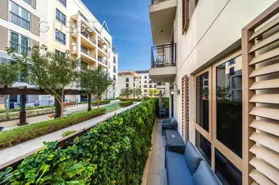 a corridor of a building with benches and plants at La Cote by Merass, La Mer Dubai in Dubai