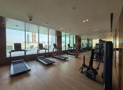 a gym with treadmills and ellipticals in a building at Homes Beyond l 1BR Cozy Modern Escape in JVC in Dubai