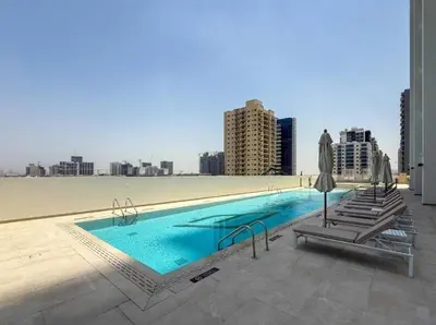 a swimming pool on a building with a view of a city at Homes Beyond l 1BR Cozy Modern Escape in JVC in Dubai