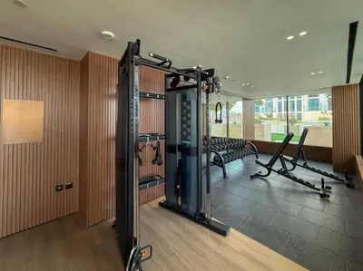 a large room with a gym with a simulator at Homes Beyond l 1BR Cozy Modern Escape in JVC in Dubai
