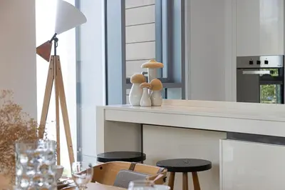 a table with a lamp and a table with chairs at 2 Bedroom Bluewaters Retreat with Office and Pool Views in Dubai