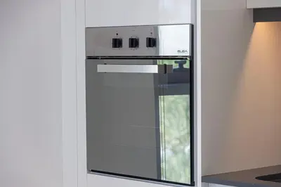 a white oven in a kitchen with a window at 2 Bedroom Bluewaters Retreat with Office and Pool Views in Dubai