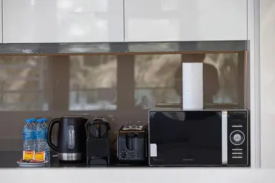 a microwave sitting on a counter next to other appliances at 2 Bedroom Bluewaters Retreat with Office and Pool Views in Dubai