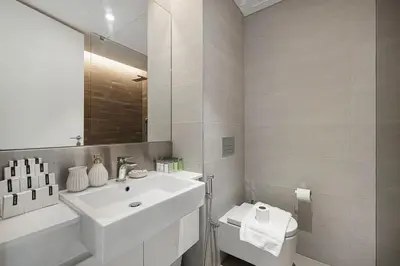 a white bathroom with a sink and a toilet at Luxury 2 Bedroom Apartment with Maids Room and Large Terrace in Dubai