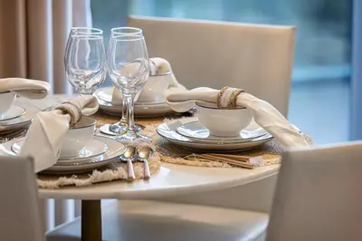 a table with plates and wine glasses on it at Luxury 2 Bedroom Apartment with Maids Room and Large Terrace in Dubai