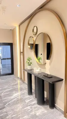 a table in a room with a round mirror at Chic 1BR Retreat with Infinity Pool and Sauna in JVC, Dubai in Dubai