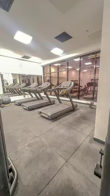 a row of empty benches in a gym at Chic 1BR Retreat with Infinity Pool and Sauna in JVC, Dubai in Dubai